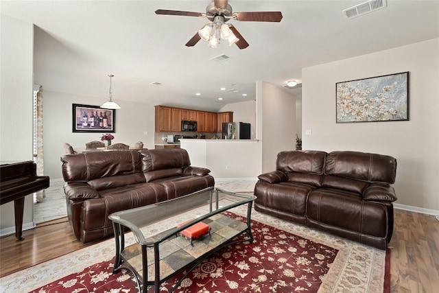 living room with ceiling fan and light wood-type flooring