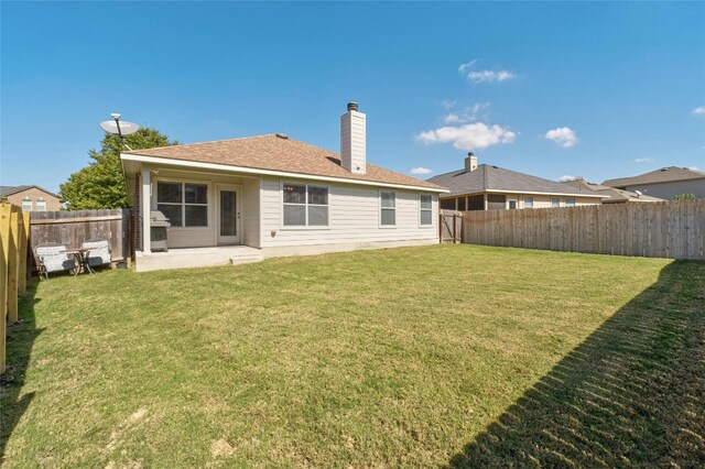 rear view of house featuring a yard