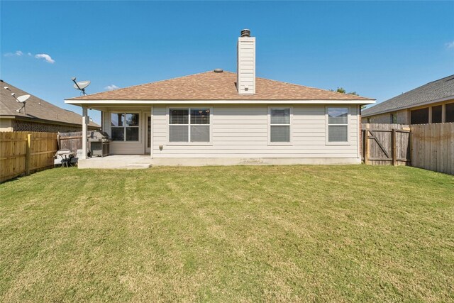 rear view of property featuring a yard and a patio area