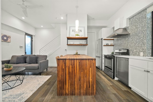 kitchen featuring dark hardwood / wood-style flooring, hanging light fixtures, appliances with stainless steel finishes, and white cabinets