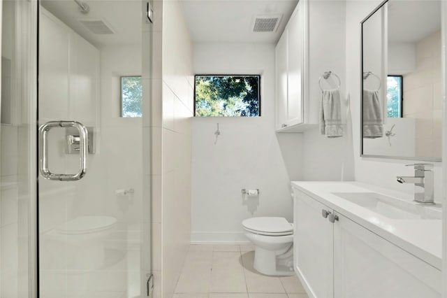 bathroom with vanity, toilet, plenty of natural light, and a shower with door