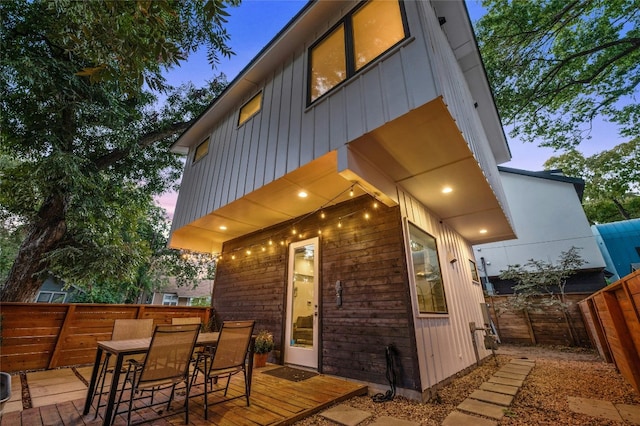back of house with a wooden deck and board and batten siding
