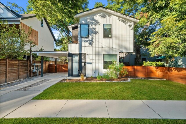 view of front of house featuring fence, an attached carport, and board and batten siding