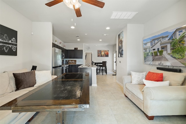 living room with sink, light tile patterned flooring, and ceiling fan