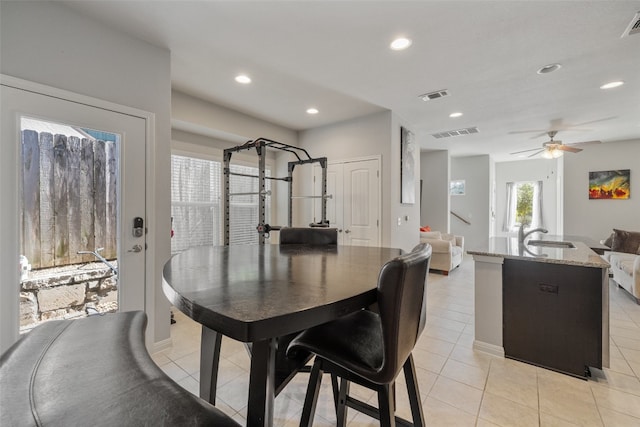 tiled dining room featuring sink and ceiling fan