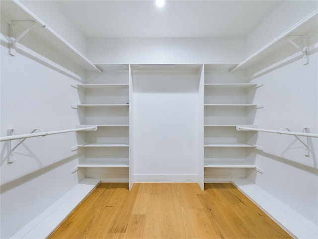 walk in closet with hardwood / wood-style floors