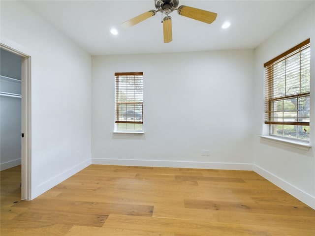 unfurnished bedroom with a closet, light hardwood / wood-style flooring, multiple windows, and ceiling fan