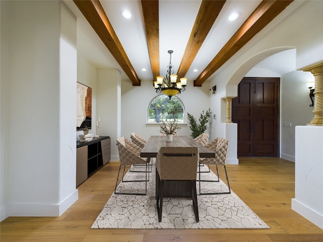 dining space featuring beam ceiling, an inviting chandelier, and light hardwood / wood-style floors