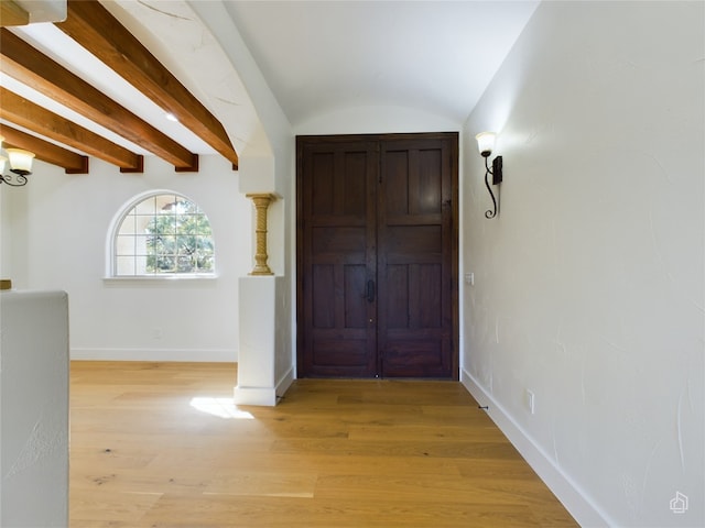 foyer with light hardwood / wood-style floors and lofted ceiling with beams