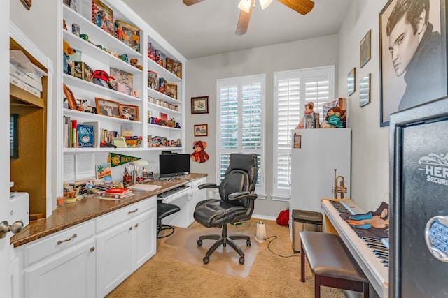 carpeted home office featuring ceiling fan