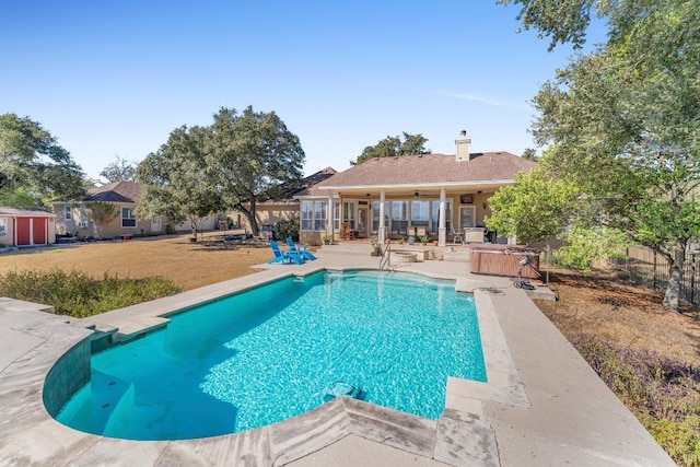 view of swimming pool featuring ceiling fan, a yard, a patio, and a hot tub