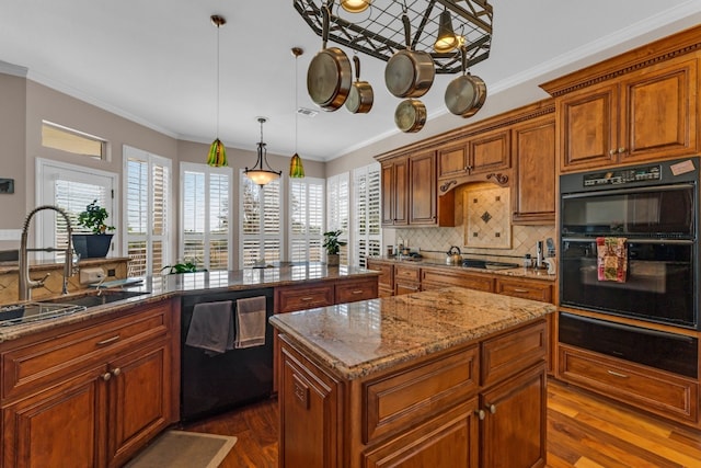 kitchen featuring a center island, dark wood-type flooring, pendant lighting, black appliances, and ornamental molding