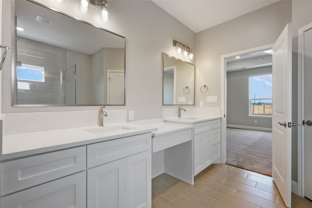 bathroom with vanity, wood-type flooring, and tiled shower