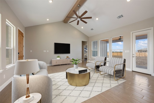 living room featuring beam ceiling, high vaulted ceiling, light wood-type flooring, and ceiling fan