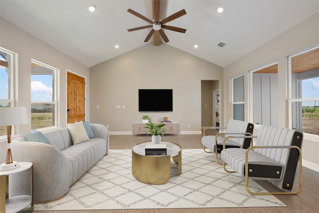 living room featuring ceiling fan, lofted ceiling, plenty of natural light, and light hardwood / wood-style floors