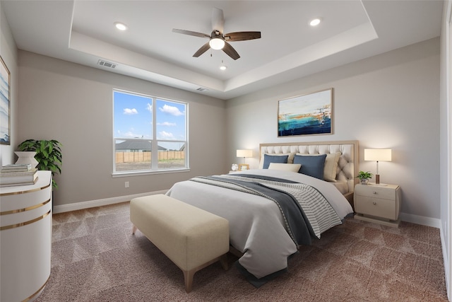 bedroom featuring ceiling fan, carpet floors, and a raised ceiling