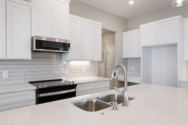 kitchen with sink, appliances with stainless steel finishes, decorative backsplash, and white cabinets