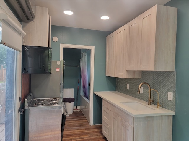 kitchen with sink, electric range, decorative backsplash, and dark hardwood / wood-style floors