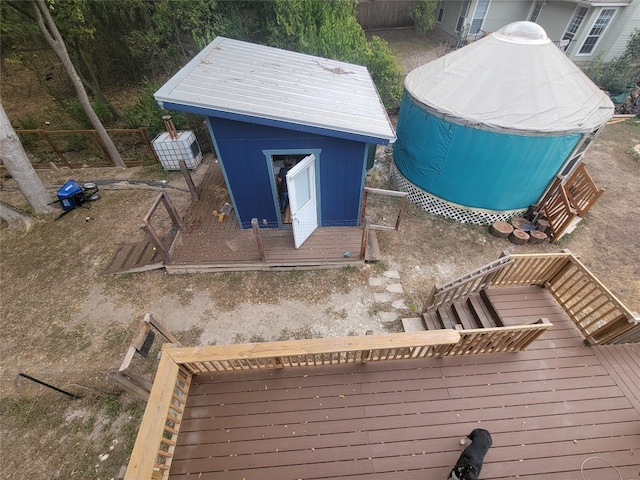 wooden deck featuring a pool and an outdoor structure