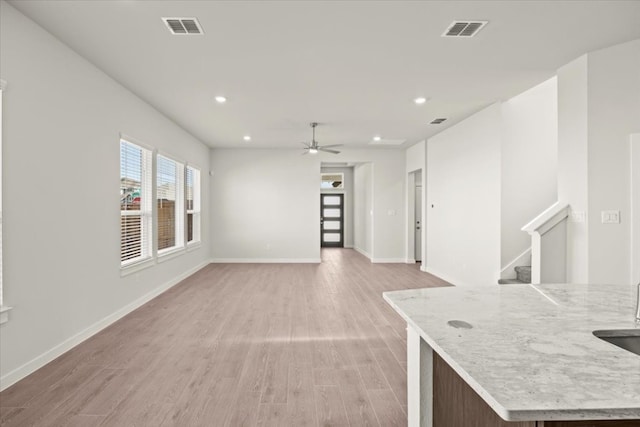 unfurnished living room featuring ceiling fan and light hardwood / wood-style flooring