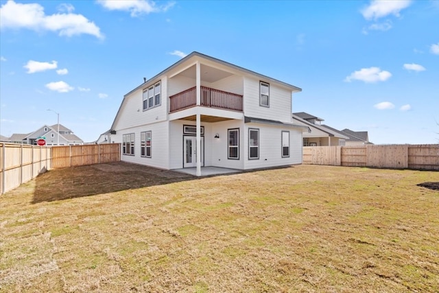 back of property featuring a patio area, a yard, and a balcony