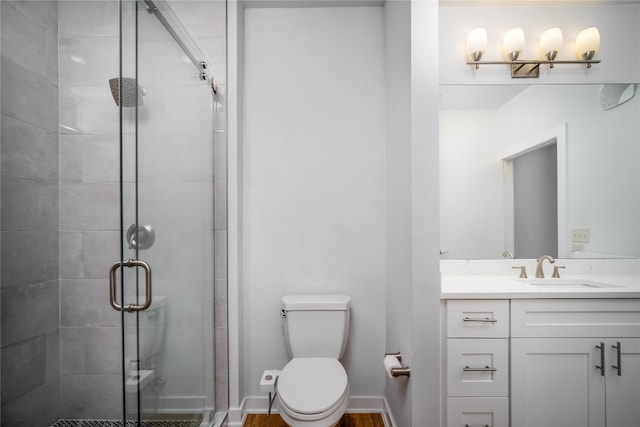 bathroom with a shower with door, toilet, and vanity