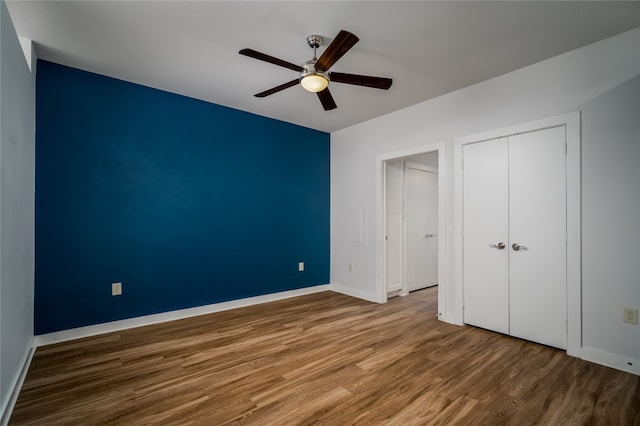 unfurnished bedroom with a closet, ceiling fan, and hardwood / wood-style flooring