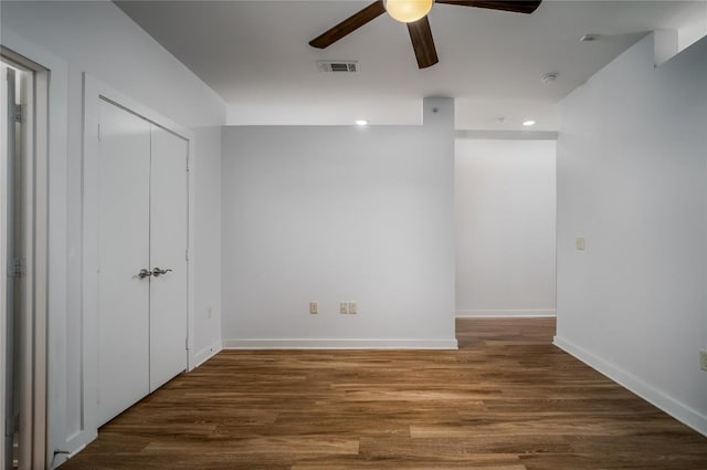 interior space with ceiling fan, baseboards, wood finished floors, and visible vents