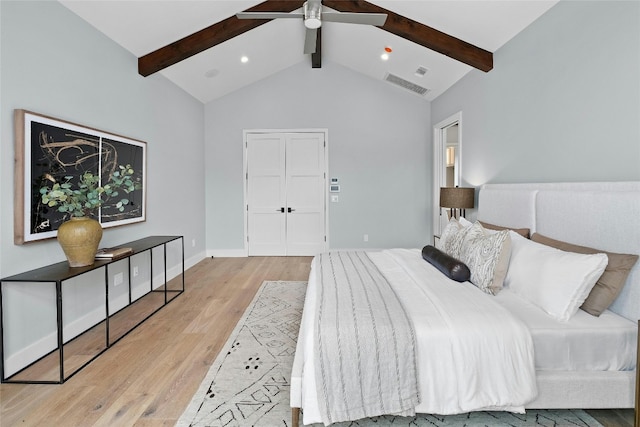 bedroom featuring light hardwood / wood-style floors, lofted ceiling with beams, and ceiling fan