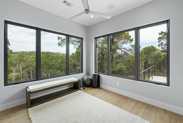 unfurnished sunroom with ceiling fan and plenty of natural light