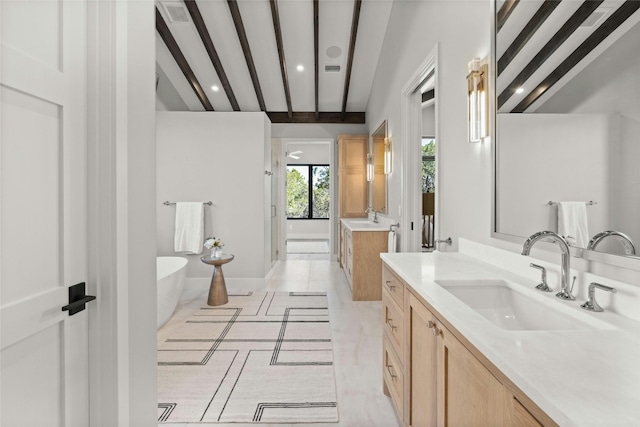 bathroom with beamed ceiling, vanity, and a tub to relax in