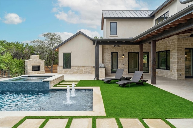 rear view of property with an outdoor fireplace, a patio, and a yard