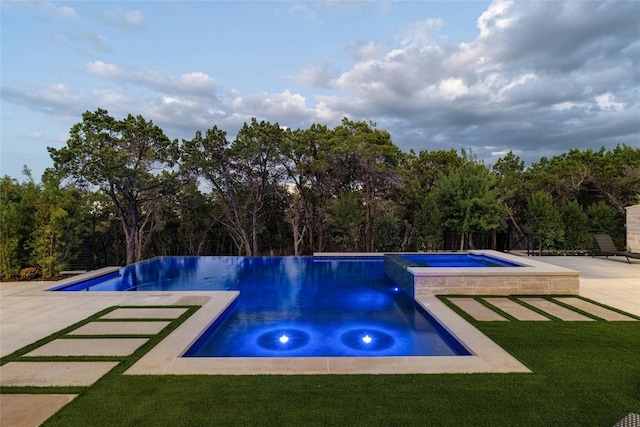 view of pool with an in ground hot tub, a patio, and a lawn