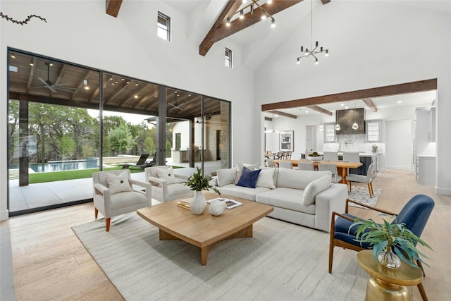 living room featuring a notable chandelier, high vaulted ceiling, beam ceiling, and light wood-type flooring