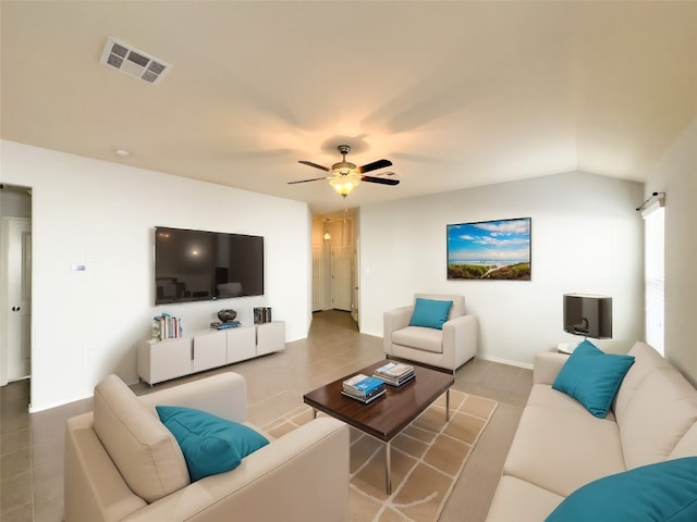 tiled living room featuring ceiling fan and vaulted ceiling