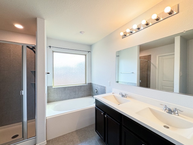 bathroom with vanity, a textured ceiling, shower with separate bathtub, and tile patterned flooring