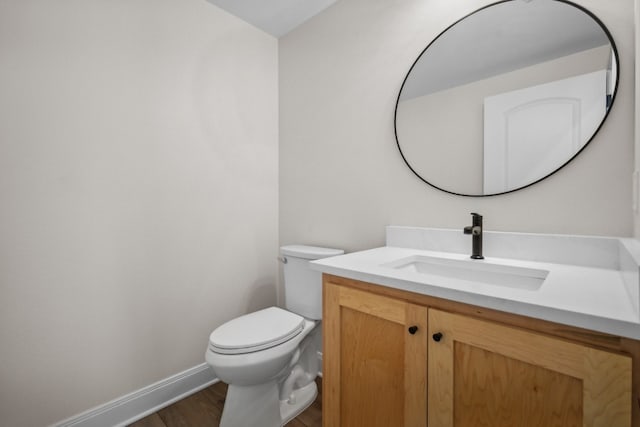 bathroom with vanity, wood-type flooring, and toilet