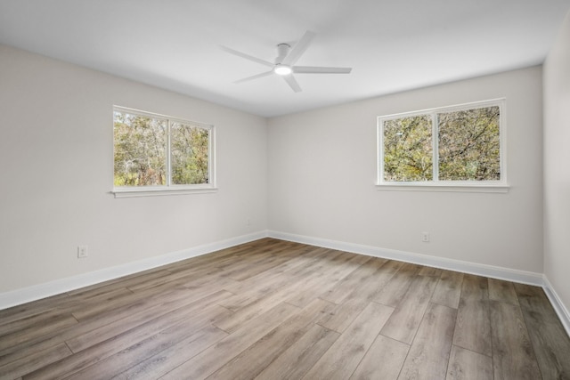 empty room featuring light hardwood / wood-style floors, a wealth of natural light, and ceiling fan