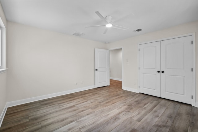 unfurnished bedroom with a closet, light wood-type flooring, and ceiling fan