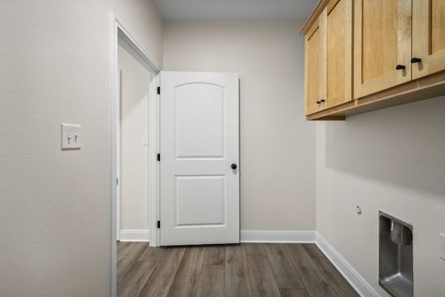 clothes washing area with dark hardwood / wood-style floors and cabinets