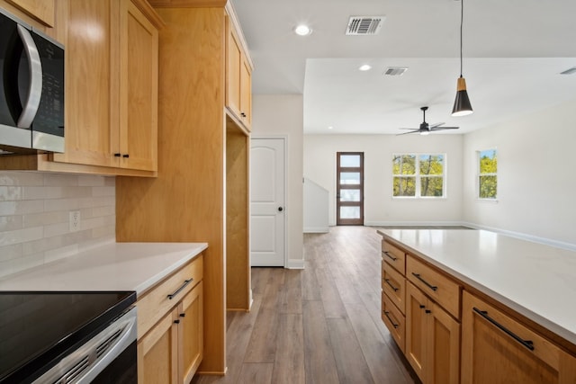 kitchen featuring decorative backsplash, ceiling fan, light wood-type flooring, electric stove, and decorative light fixtures