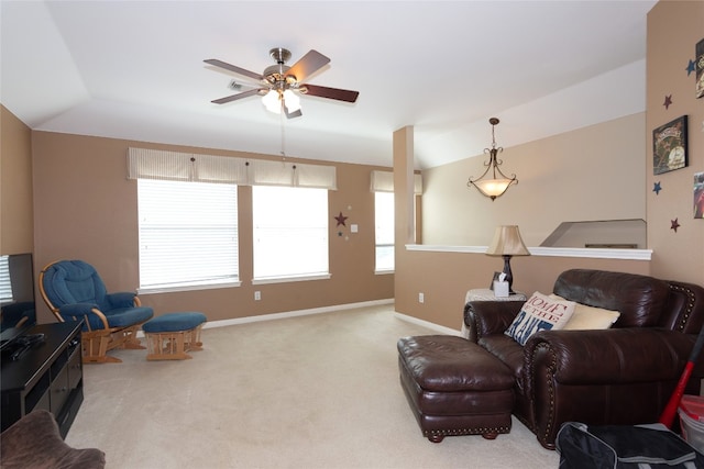 carpeted living room with ceiling fan and vaulted ceiling