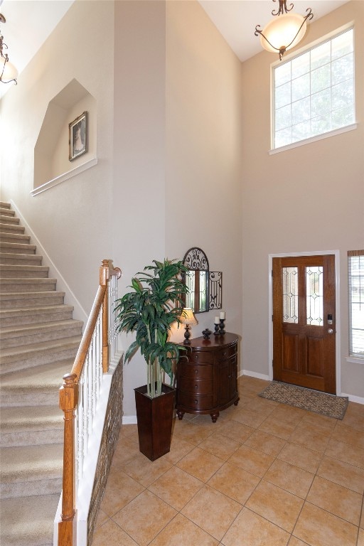 tiled entryway featuring a towering ceiling