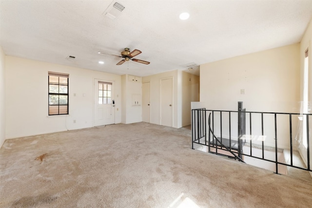 unfurnished room featuring light colored carpet and ceiling fan