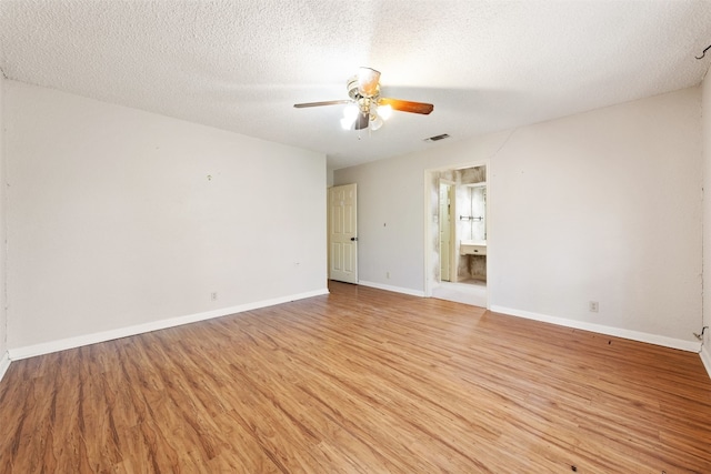 unfurnished room featuring a textured ceiling, light wood-type flooring, and ceiling fan