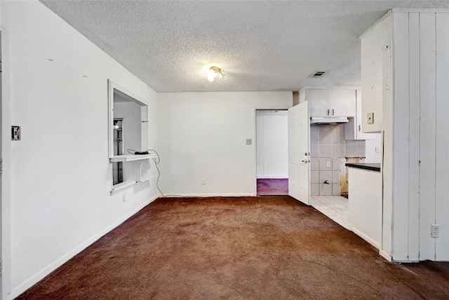 interior space with dark colored carpet and a textured ceiling