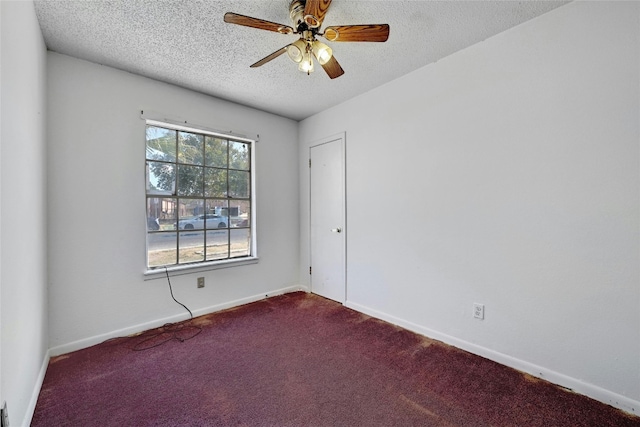 carpeted spare room featuring a textured ceiling and ceiling fan