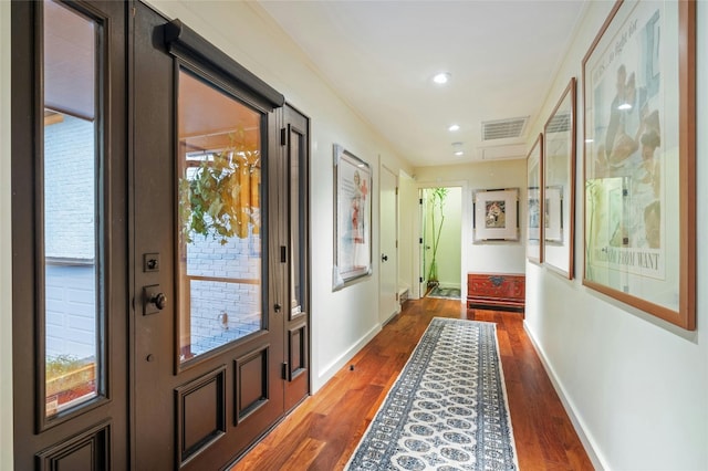 doorway to outside featuring ornamental molding and dark hardwood / wood-style floors