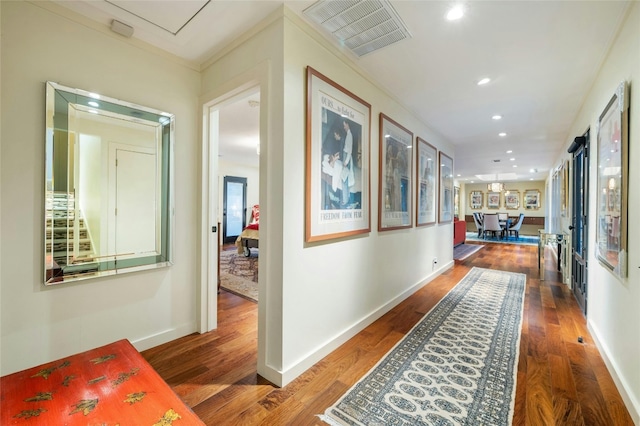 hall featuring ornamental molding and dark hardwood / wood-style flooring