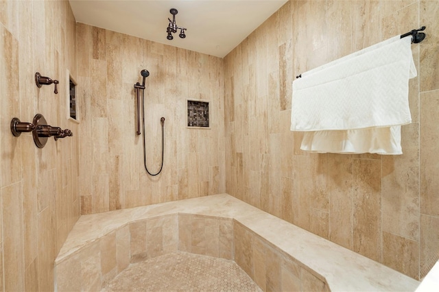 bathroom with a tile shower and tile walls